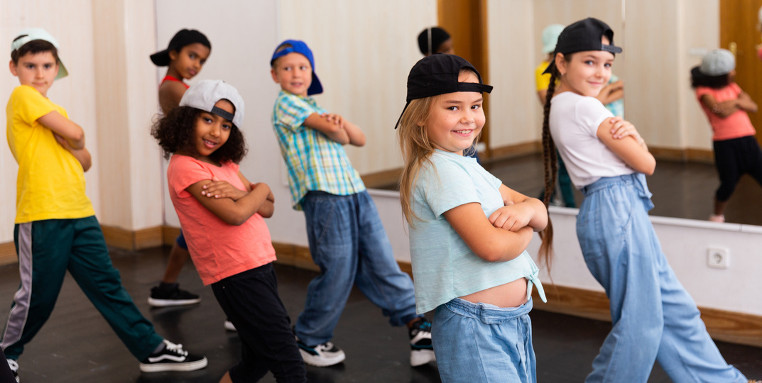 Children training hip hop movements in dance class